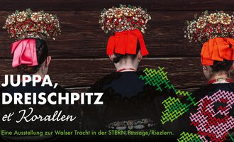 Three people wearing traditional hats and colorful costumes stand back to back. In the background, a dark wooden surface can be seen. | © Trachtengruppe Kleinwalsertal