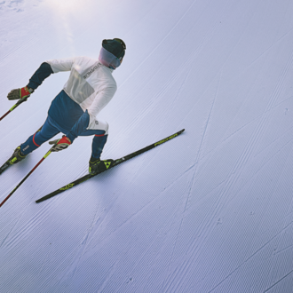 A skier glides down a perfectly groomed slope. The clear, snow-covered surroundings radiate calm and focus. | © @Oliver Farys | Kleinwalsertal Tourismus