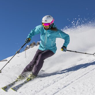 A skier is riding on a snowy slope. The clear blue sky and the snow create a beautiful winter atmosphere. | © GENUSS & AKTIVHOTEL SONNENBURG
