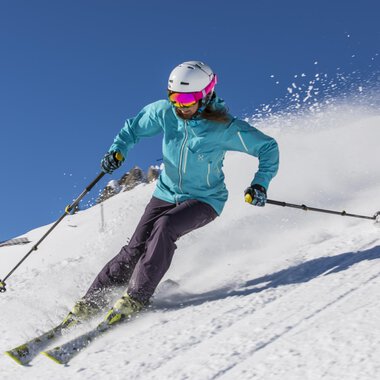A skier is riding on a snowy slope. The clear blue sky and the snow create a beautiful winter atmosphere. | © GENUSS & AKTIVHOTEL SONNENBURG
