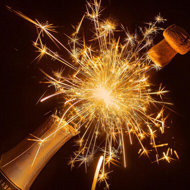 A champagne bottle with a bubbling cork and sparks that sparkle. A festive sight full of joy and celebration. | © Myriams-Fotos | Pixabay