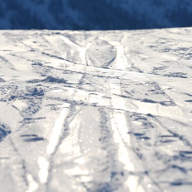 A snow-covered surface with ski tracks. The light reflects off the smooth surface. | © Kleinwalsertal Tourismus | Frank Drechsel