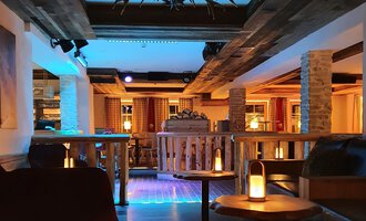 Eine gemütliche Bar mit Holzdekor und sanfter Beleuchtung. Die Sitzecken laden zum Entspannen ein. | © Hotel Steinbock