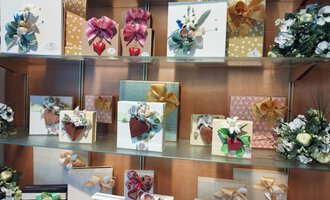 A depiction of various beautifully wrapped gifts on a shelf. The gifts are adorned with colorful ribbons and decorations. | © Kleinwalsertal Tourismus | N. Lughammer