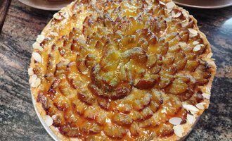A delicious plum cake with a decorative surface. The cake has a golden color and is garnished with almonds. | © Kleinwalsertal Tourismus | N. Lughammer