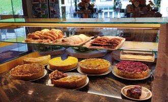 A selection of delicious cakes and pastries in a display case. The treats shine in various colors and shapes. | © Kleinwalsertal Tourismus | N. Lughammer