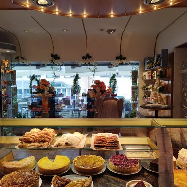 A cozy pastry shop with a selection of delicious baked goods. The space is brightly lit and offers a view of a beautiful courtyard. | © Kleinwalsertal Tourismus | N. Lughammer