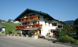 A picturesque building in alpine style with blooming balconies. It is situated in a quiet, green surrounding. | © Cafe Jochum | Bernadette Reinmuth