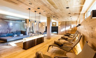 An elegant wellness area with wooden paneling and modern loungers. The room is bright and offers a relaxing atmosphere. | © Genuss- & Aktivhotel Sonnenburg | Werner Krug