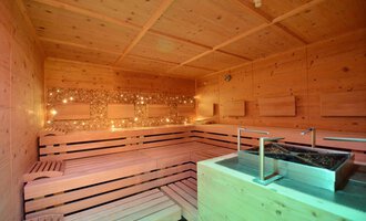 Eine gemütliche Sauna mit Holzbank und sanfter Beleuchtung. Der Raum strahlt Entspannung und Wärme aus. | © Hotel Alpenstüble Appartements | Manuel Riezler
