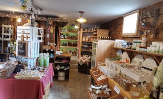 A cozy store with wooden walls that offers various products such as gifts and local foods. The ambiance is inviting and friendly. | © Dies & Das Hofladen | V. Wächter