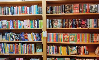 Ein Bücherregal mit vielen bunten Büchern. Die Bücher sind in mehreren Reihen ordentlich angeordnet. | © Kleinwalsertal Tourismus | N. Lughammer