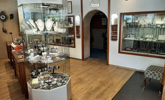 Ein Juweliergeschäft mit einem Schmuckdisplay in der Mitte. An den Wänden sind weitere Schmuckstücke in Vitrinen ausgestellt. | © Juwelier Demsky Walser Goldschmiede| Veronika Senn