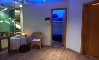 A quiet room with warm light and a wooden floor. There is a table and a chair that create a cozy atmosphere. | © Schönzeit | Sebastian Riezler