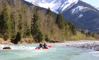 A kayaker on a clear river surrounded by mountains and forests. The mountain landscape is impressive and nature feels alive. | © MAP-Erlebnis