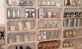 A wooden shelf full of cups, candles, and other decorative items. In the background, some decorative mountains can be seen. | © Herzstichle | Ninja Matt
