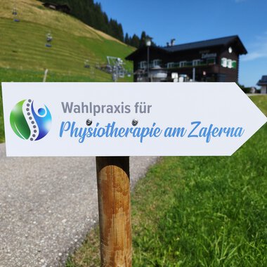 A sign points to the election practice for physiotherapy at Zaferna. The surroundings are green and mountainous, ideal for relaxation. | © Kleinwalsertal Tourismus | N. Lughammer