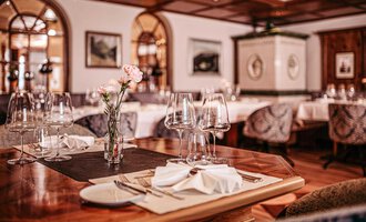 An elegant restaurant with beautifully set tables and stylish decor. Soft lighting and decorative elements create an inviting atmosphere. | © Hotel Birkenhöhe | Sascha Gast