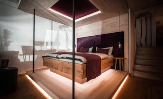 Ein modernes Schlafzimmer mit einem Holzbett und eleganten Akzenten. Sanftes Licht schafft eine gemütliche Atmosphäre. | © Türtscher Die Schreinermanufaktur