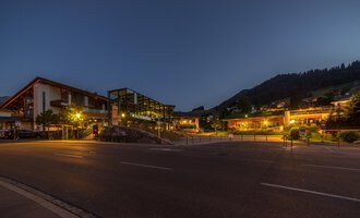 A picturesque place at night with illuminated buildings and gentle hills in the background. The calm atmosphere invites you to linger. | © Kleinwalsertal Tourismus |  Steffen Berschin