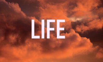 A colorful sunset with clouds in warm tones. In the foreground stands the word "LIFE" in large letters.